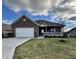 Brick ranch home with attached garage and landscaped lawn at 5375 E Commons West Dr, Mooresville, IN 46158