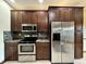 Modern kitchen, stainless steel appliances, dark wood cabinets, granite countertops at 5375 E Commons West Dr, Mooresville, IN 46158