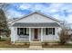 Charming white bungalow with a front porch and red door at 65 Central Ave, Franklin, IN 46131