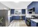 Bright kitchen boasts modern blue cabinets, stainless steel appliances, and quartz countertops at 65 Central Ave, Franklin, IN 46131