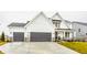 Two-story farmhouse with gray double garage and stone accents at 19983 Chatham Green Dr, Westfield, IN 46074