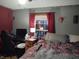 Bedroom with a bed, desk, and window with red curtains at 8041 S Peoga Rd, Trafalgar, IN 46181