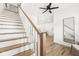 Modern white staircase with wooden handrail and hardwood floors at 305 Parkway Ave, Indianapolis, IN 46225
