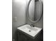 Small bathroom with gray vanity, oval mirror, and white sink at 3682 Newgate Ln, Indianapolis, IN 46235