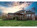 Brick home with pergola, patio, and lush lawn at 2569 Dawn Ridge Dr, Carmel, IN 46074