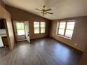 Living room with dark laminate flooring, ceiling fan, and multiple windows at 3088 N Alaska Rd, Cloverdale, IN 46120