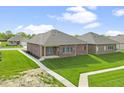 Rear view of brick home with grassy backyard and sidewalk at 5488 E Shae Lake Dr, Mooresville, IN 46158