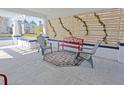 Relaxing front porch with red metal bench and gray chairs at 412 W 11Th St, Anderson, IN 46016