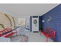 Inviting front porch with red benches, a floral rug, and a wooden privacy screen at 412 W 11Th St, Anderson, IN 46016
