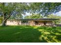 Brick ranch house with a covered porch and spacious lawn at 2129 Woodcrest Rd, Indianapolis, IN 46227