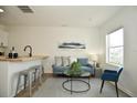 Living area features a teal couch, coffee table, and a kitchen island with barstools at 2215 Lexington Ave, Indianapolis, IN 46203