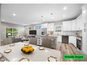 Modern kitchen with white cabinets, island, and dining area at 3368 Johns Way, Greenwood, IN 46143