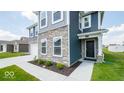 Two-story home with stone and blue siding, welcoming front entrance and landscaping at 1448 Buttercup Ln, Shelbyville, IN 46176