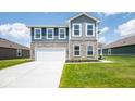 Two-story home with gray siding, stone accents, and a white garage door at 1448 Buttercup Ln, Shelbyville, IN 46176