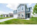 Two-story home with gray siding, stone accents, and a white garage door at 1448 Buttercup Ln, Shelbyville, IN 46176