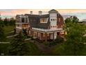 Impressive aerial showcasing a brick farmhouse with multiple levels and balconies at 9825 Windy Hills Dr, Zionsville, IN 46077