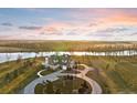 Breathtaking sunset aerial view of a large farmhouse nestled on a private lot near a lake at 9825 Windy Hills Dr, Zionsville, IN 46077