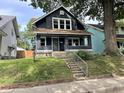 Charming two-story home with dark gray siding and a landscaped yard at 320 Northern Ave, Indianapolis, IN 46208