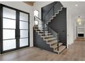 Modern staircase with glass railing and dark wood feature wall at 9280 Highpointe Ln, Zionsville, IN 46077