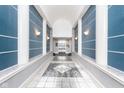 Elegant hallway with blue walls, marble floors, and columns leading to an elevator at 8751 Jaffa Court E Dr # 35, Indianapolis, IN 46260