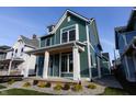 Two-story craftsman home with a teal exterior, white trim, and a welcoming front porch at 2133 N Talbott St, Indianapolis, IN 46202