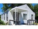 White house with black accents, covered porch, and deck at 3106 Newton Ave, Indianapolis, IN 46201