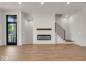 Bright living room with hardwood floors, fireplace, and modern staircase at 673 E 16Th St, Indianapolis, IN 46202