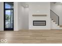 Modern living room with fireplace, hardwood floors, and large windows at 675 E 16Th St, Indianapolis, IN 46202