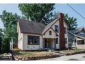 Two-story home with brick chimney and mature trees at 819 E 49Th St, Indianapolis, IN 46205