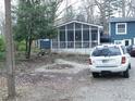 Screened porch and backyard with a gravel driveway at 1515 Randall Rd, Indianapolis, IN 46240