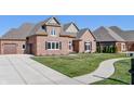 Brick house with a two-car garage and landscaped yard at 4212 Stone Lake Dr, Zionsville, IN 46077