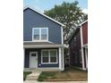 Two-story navy blue duplex home with a tree and neighboring building at 221 N Temple Ave, Indianapolis, IN 46201