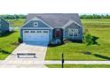 Aerial view of a blue and gray house with a yard and driveway at 6941 E Bean Blossom Dr, Camby, IN 46113