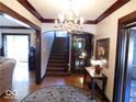 Bright entryway with hardwood floors, chandelier, and staircase at 909 E 38Th St, Indianapolis, IN 46205