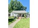 Ranch home with gray siding, red door, and porch at 1618 N Linwood Ave, Indianapolis, IN 46218