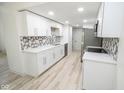 Modern white kitchen with new appliances and hexagonal tile backsplash at 2424 N Willow Way, Indianapolis, IN 46268