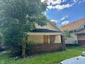 A yellow sided house with boarded windows needing renovation at 642 N Oxford St, Indianapolis, IN 46201