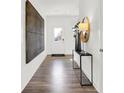 Bright entryway with hardwood floors, a modern console table, and large wall art at 3422 Wetherby Pl, Danville, IN 46122