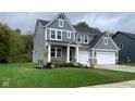 Two-story house with gray siding, brick accents and landscaping at 6272 Willow Branch Way, Plainfield, IN 46168
