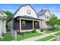Charming renovated home with a modern black and white exterior, a welcoming porch, and well-manicured lawn at 1134 St Peter St, Indianapolis, IN 46203