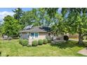 Stone house with solar panels and a small front yard at 11445 N School St, Fishers, IN 46038
