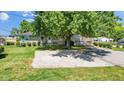 Stone house with a large tree and gravel driveway at 11445 N School St, Fishers, IN 46038