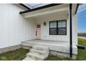 Inviting front porch with pink door and black window frames at 706 S Main St, Whitestown, IN 46075