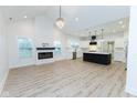 Open floor plan with kitchen island, fireplace, and hardwood floors at 706 S Main St, Whitestown, IN 46075
