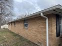 Side view of a brick ranch-style home with white gutters and downspouts at 1632 W 7Th St, Anderson, IN 46016