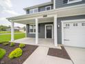 Covered front porch with white columns and black door at 5714 Cattail Branch Ln, Clayton, IN 46118