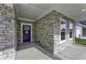 Stone front entrance with a blue door and a small covered porch at 11451 Neptune Dr, Fishers, IN 46040