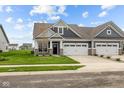 Craftsman style home with gray siding, stone accents, and a two-car garage at 16910 Cattle Hollow Ln, Noblesville, IN 46060