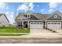 Craftsman style home with gray siding, stone accents, and a two-car garage at 16910 Cattle Hollow Ln, Noblesville, IN 46060