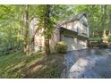 Two car garage with driveway and wooded surroundings at 6235 Johnson Rd, Indianapolis, IN 46220